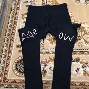 Black leggings with MEOW written on the knees